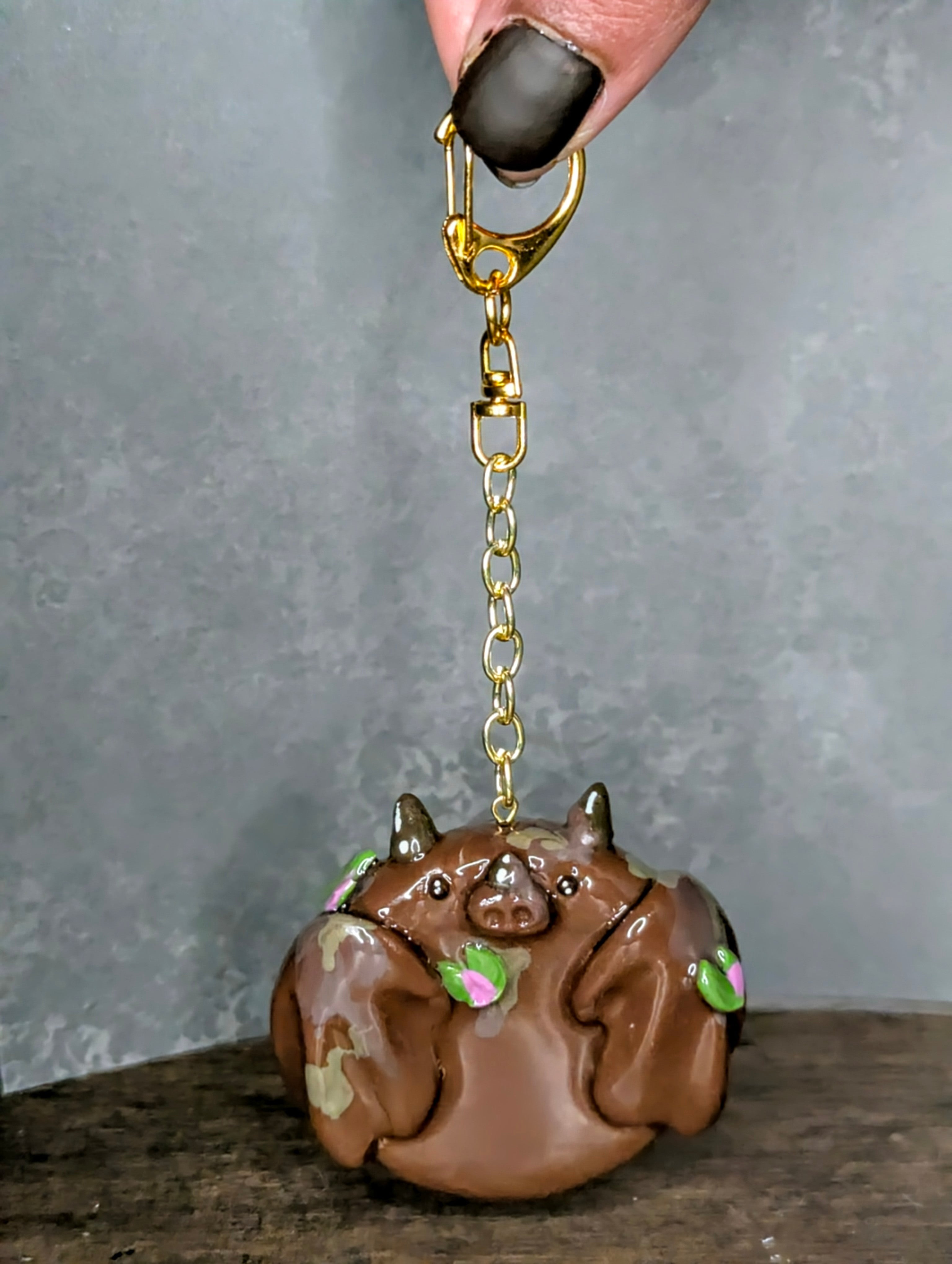 Brown animal-shaped keychain with gold chain Handcrafted mud dragon worry stone in earthy brown tones